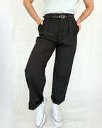 Woman wearing black pleated pants with a rolled cuff