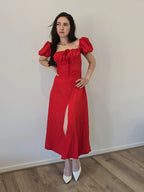 Womans elegant red dress with puff sleeves and split