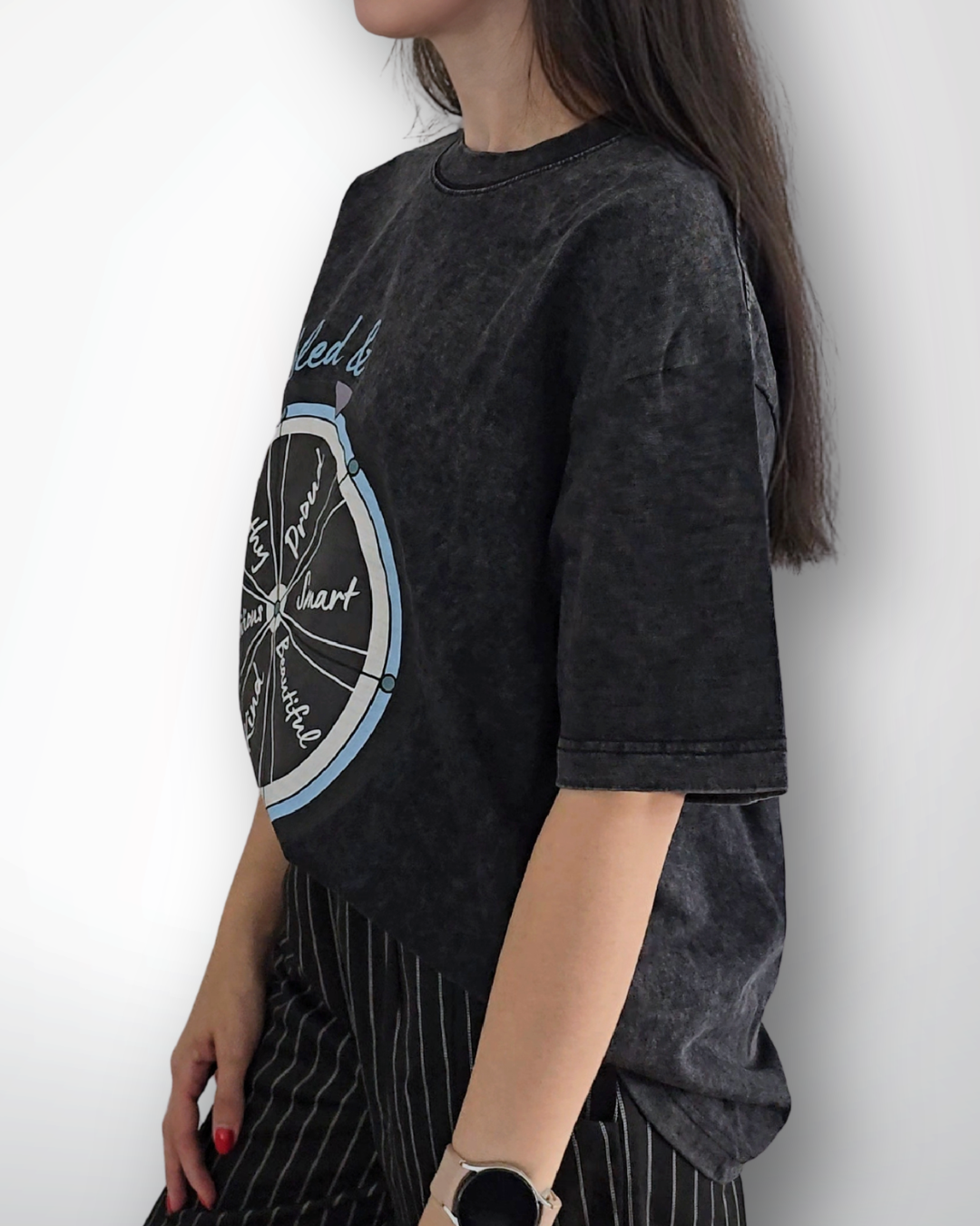 Woman wearing a black t-shirt with a graphic design against a white background