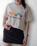 Person wearing a beige t-shirt with colorful flower graphics and text against a white background