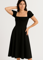 Woman wearing a black summer dress with puff sleeves on a white background