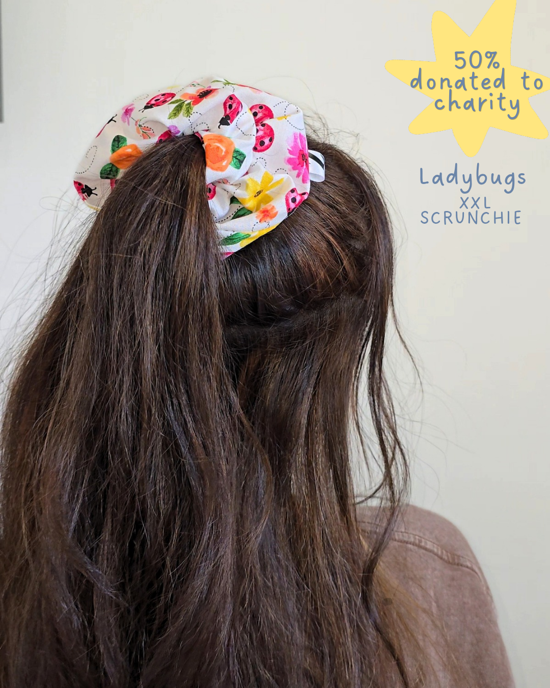 Scruncheon with ladybug design on hair against a white background, text indicating 50% donated to charity.