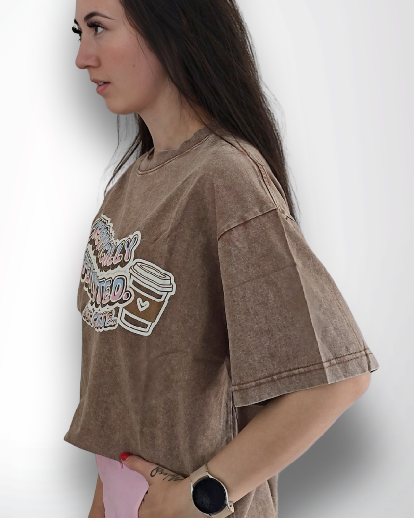 Woman wearing a brown oversized shirt with a graphic design on a white background