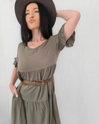 Woman wearing a green dress with a brown belt and hat melbourne models