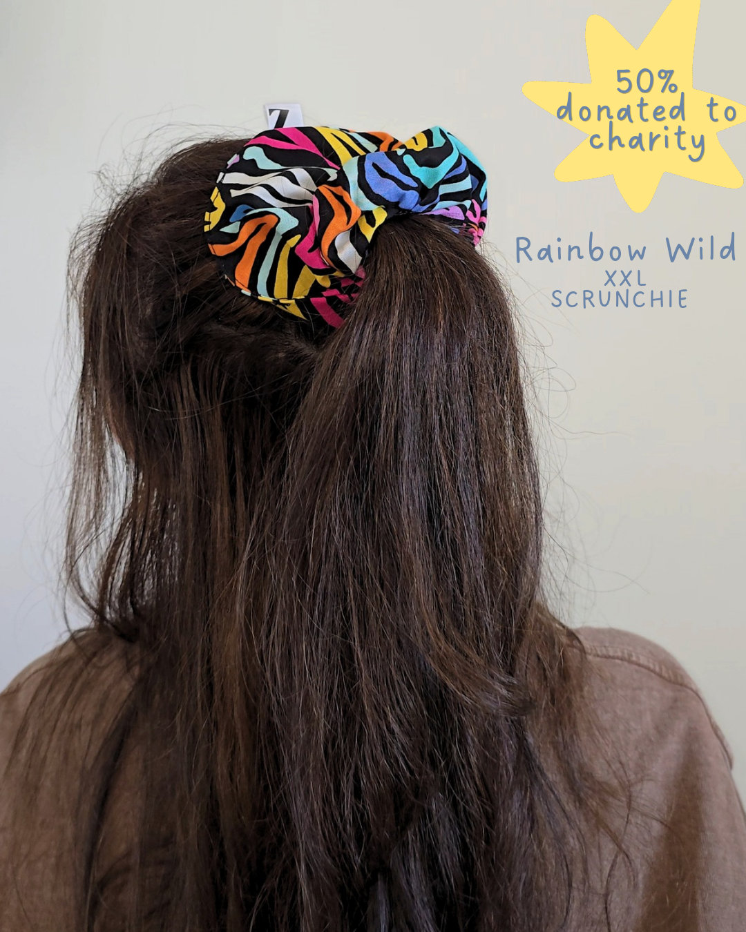 Person wearing a colorful scrunchie with text indicating charity donation and product name.