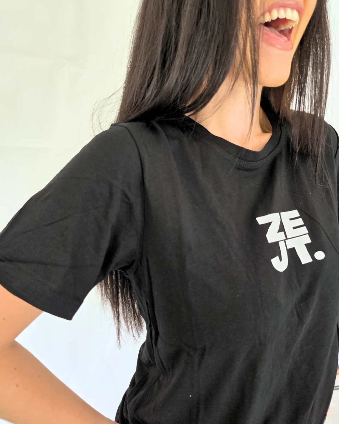 Person wearing a black t-shirt with a white logo streetwear style